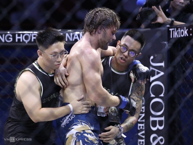 Chiến thuật giúp Phạm Công Minh đánh bại Zakhar trên sàn MMA Zakhar Dzmitrychenka (giữa) được dìu sau hiệp hai, trước khi xin dừng trận đấu. Ảnh: Hiếu Lương Nguồn: VNEXPRESS